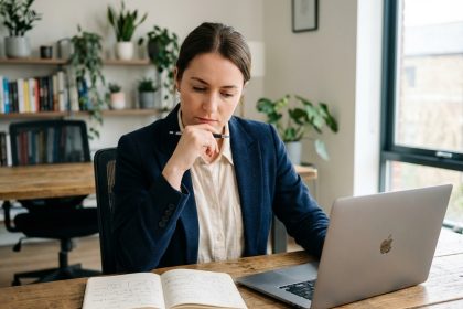 Jeune femme concentrée au bureau avec ordinateur et notes